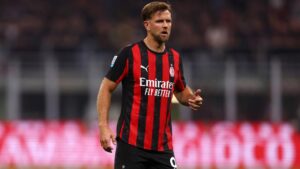 Niclas Füllkrug im Trikot der AC Mailand jubelt nach einem wichtigen Auswärtssieg in der Serie A auf dem Rasen.