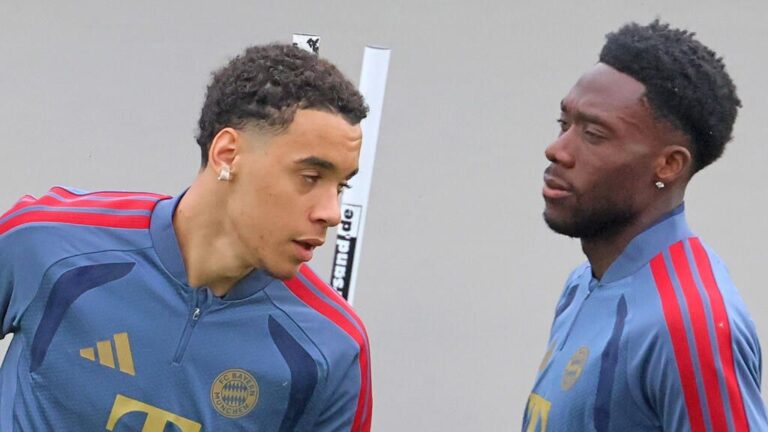Alphonso Davies im Trikot des FC Bayern München fasst sich nach einer Verletzung enttäuscht an den Oberschenkel.