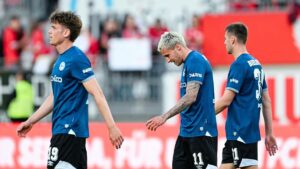 Enttäuschte Spieler von Arminia Bielefeld stehen nach einer Niederlage im Abstiegskampf der 2. Bundesliga auf dem Platz.