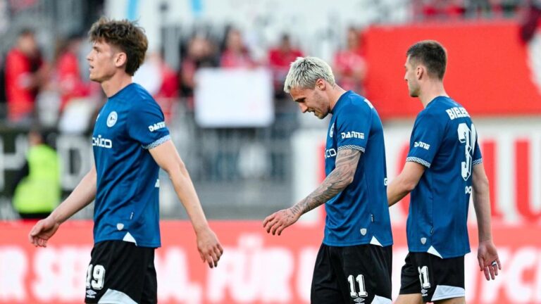 Enttäuschte Spieler von Arminia Bielefeld stehen nach einer Niederlage im Abstiegskampf der 2. Bundesliga auf dem Platz.