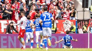 Jubelnde Spieler von Energie Cottbus nach dem Aufstieg in die 2. Bundesliga vor den Fans in Regensburg