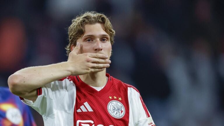 Mika Godts im Trikot von Ajax Amsterdam am Ball auf dem Spielfeld