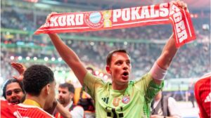 Manuel Neuer jubelt mit dem DFB-Pokal inmitten der Spieler von Bayern München im Stadion.