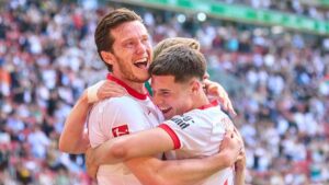 Spieler des FC Augsburg bedanken sich nach einem Bundesligaspiel jubelnd bei den mitgereisten Fans.