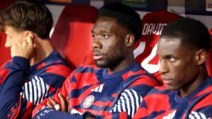 Alphonso Davies im Trikot des FC Bayern München schaut nachdenklich auf dem Spielfeld.