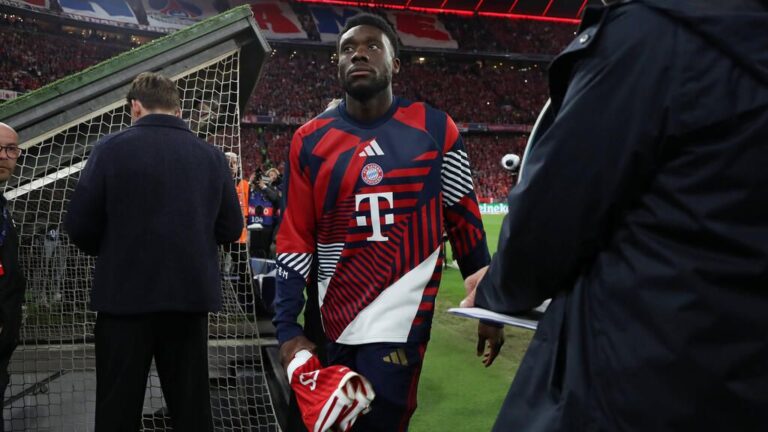 Alphonso Davies im Trikot des FC Bayern München fasst sich verletzt an den Oberschenkel