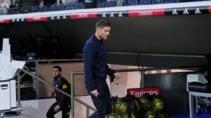 Xabi Alonso blickt nachdenklich an der Seitenlinie, im Hintergrund das Stadion an der Anfield Road.