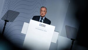 Real Madrid Präsident Florentino Pérez spricht entschlossen auf einer Pressekonferenz in ein Mikrofon.
