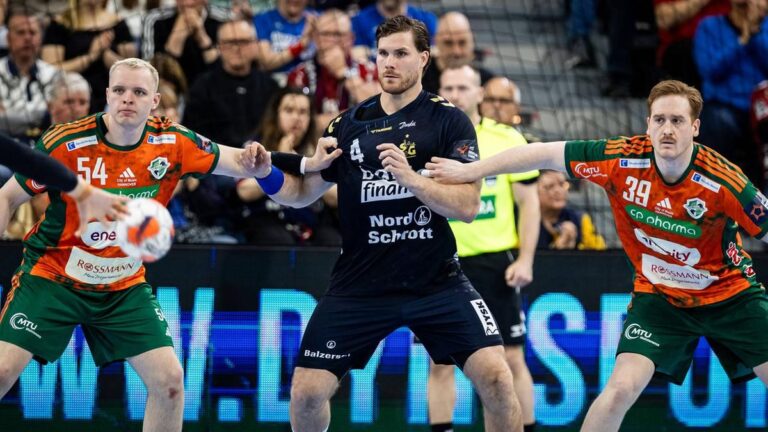 Handballspieler der TSV Hannover-Burgdorf und SG Flensburg-Handewitt in einem hitzigen Zweikampf am Kreis