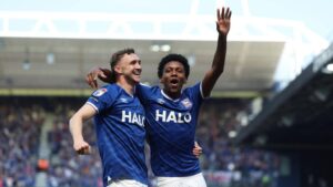 Jubelnde Spieler und Fans von Ipswich Town nach dem Aufstieg in die Premier League auf dem Rasen der Portman Road