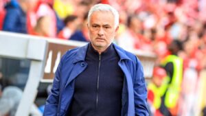 Fußballtrainer José Mourinho blickt fokussiert im Anzug an der Seitenlinie eines Fußballplatzes