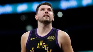 Luka Doncic im Trikot der Los Angeles Lakers sitzt enttäuscht auf der Bank während eines NBA-Spiels