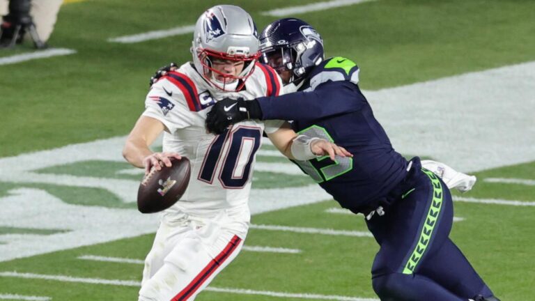 Ein Helm der Seattle Seahawks und das NFL-Logo vor einem vollbesetzten Football-Stadion bei Flutlicht
