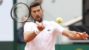Novak Djokovic und sein neuer Trainer Viktor Troicki stehen lächelnd gemeinsam auf dem Tennisplatz.