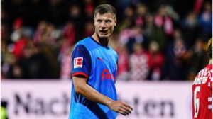 Patrick Erras im Trikot von Holstein Kiel blickt nachdenklich auf das Spielfeld.