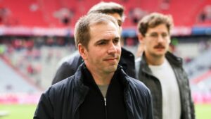 Philipp Lahm lächelt im Anzug bei einem offiziellen Pressetermin