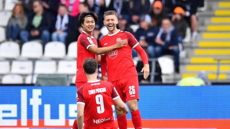 Jubelnde Spieler von Rot-Weiss Essen um Torschütze Ben Hüning nach dem Last-Minute-Sieg in Ulm