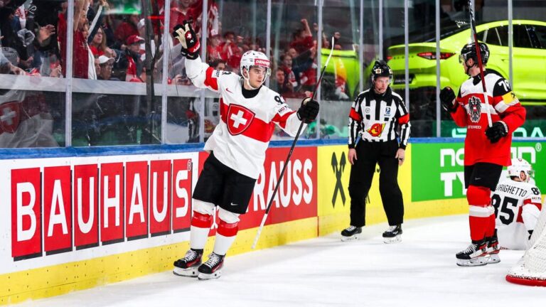 Jubelnde Eishockey-Spieler der Schweizer Nationalmannschaft im roten Trikot auf dem Eis