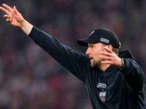 Spieler des VfB Stuttgart und Bayer Leverkusen kämpfen in einem hitzigen Zweikampf auf dem Rasen um den Ball.