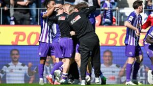 Trainer Timo Schultz und jubelnde Spieler des VfL Osnabrück feiern den Aufstieg