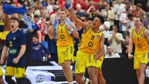 Jubelnde Spieler von Alba Berlin mit dem Meisterpokal nach dem Auswärtssieg gegen Bayern München.
