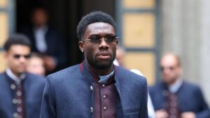 Alphonso Davies im Trikot der kanadischen Nationalmannschaft blickt nachdenklich auf den Rasen.