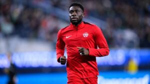 Alphonso Davies im Trikot der kanadischen Nationalmannschaft blickt fokussiert auf das Spielfeld