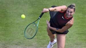 Tennisspielerin Aryna Sabalenka hochkonzentriert beim Aufschlag auf dem Rasenplatz des WTA-Turniers in Berlin.