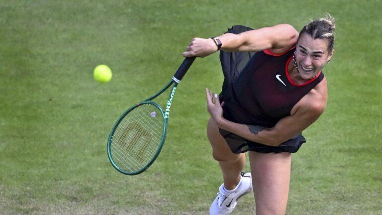 Tennisspielerin Aryna Sabalenka hochkonzentriert beim Aufschlag auf dem Rasenplatz des WTA-Turniers in Berlin.