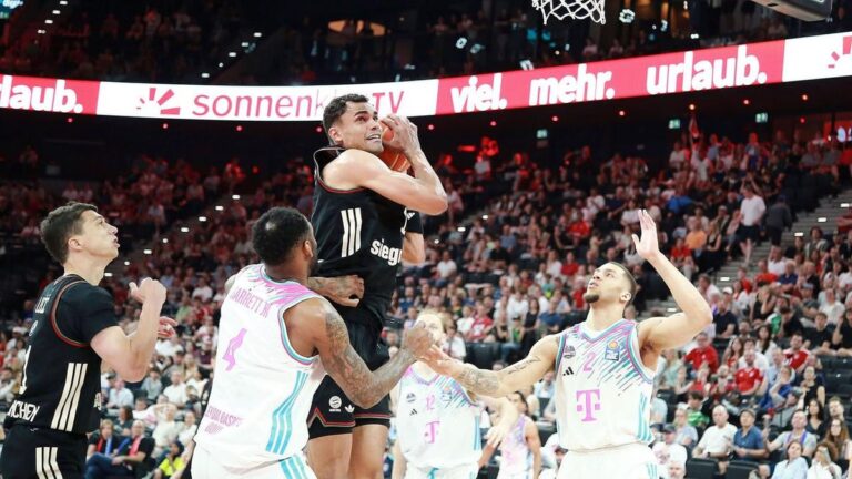 Basketballspieler des FC Bayern München beim Wurf gegen Verteidiger der Baskets Bonn