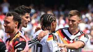 Spieler der deutschen Nationalmannschaft bejubeln im Regen einen wichtigen Treffer.