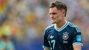 Florian Wirtz im Trikot der deutschen Nationalmannschaft blickt fokussiert auf das Spielfeld bei der Weltmeisterschaft.