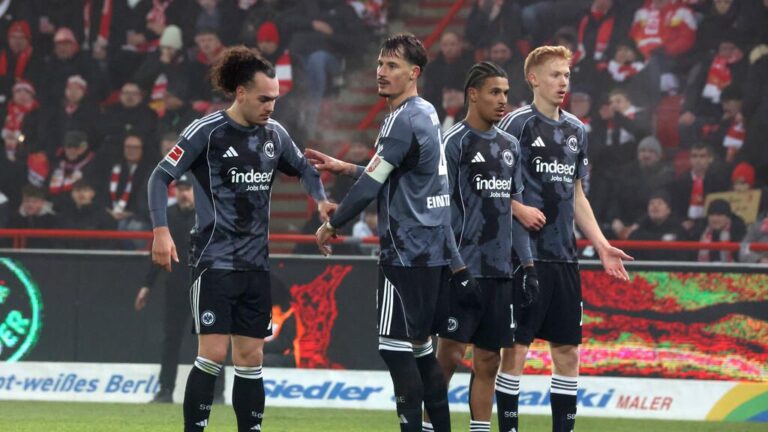 Die Eintracht-Profis Hugo Larsson und Arthur Theate stehen im Trikot von Frankfurt auf dem Spielfeld