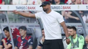 Vincent Kompany gestikuliert am Spielfeldrand neben Morgan Rogers im Trikot von Aston Villa