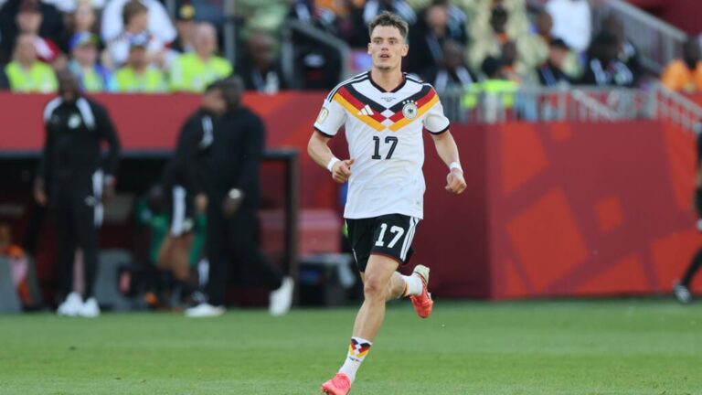 Florian Wirtz am Ball in der Premier League, während Xabi Alonso das Spiel an der Seitenlinie beobachtet.