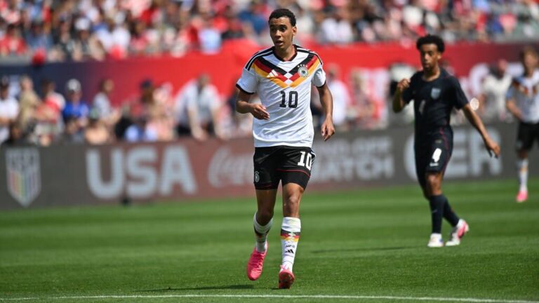 Jamal Musiala im Trikot der deutschen Nationalmannschaft mit fokussiertem Blick auf dem Spielfeld