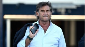 Giovanni Carnevali lächelt im Anzug, im Hintergrund ist das Wappen von Juventus Turin zu sehen