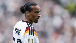 Joshua Kimmich und Leroy Sané im Trikot der deutschen Nationalmannschaft im Gespräch auf dem Spielfeld.