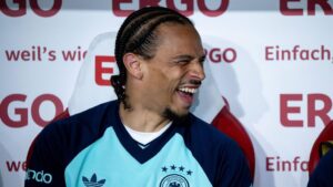 Leroy Sané lächelt im Training der deutschen Nationalmannschaft und gibt den Fans geduldig Autogramme.