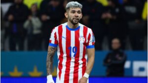 Julio Enciso von Paraguay sitzt verletzt und weinend auf dem Rasen, während medizinische Betreuer ihm helfen.