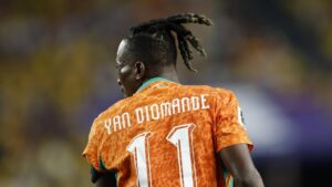 Yan Diomande im Trikot von RB Leipzig sprintet mit dem Ball am Fuß über den Rasen.