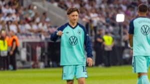 Angelo Stiller im Trikot des VfB Stuttgart blickt konzentriert über den Platz