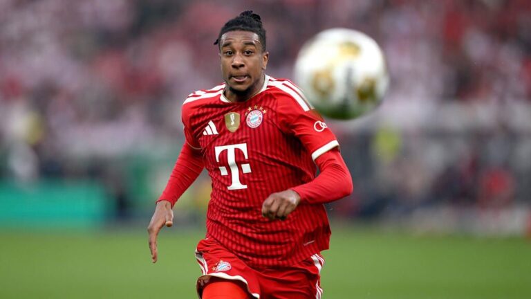 Michael Olise im Trikot des FC Bayern München blickt konzentriert auf dem Spielfeld