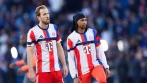 Michael Olise im Trikot des FC Bayern München dribbelt mit dem Ball auf dem Spielfeld.