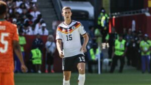 Nico Schlotterbeck im Trikot von Borussia Dortmund blickt ernst und nachdenklich auf das Spielfeld.