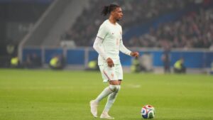 Michael Olise im Trikot des FC Bayern München mit dem Ball am Fuß