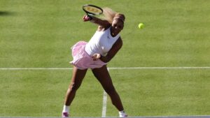 Serena Williams im Tennis-Outfit beim Aufschlag auf einem Rasenplatz während eines WTA-Turniers