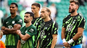 Ein enttäuschter Spieler des VfL Wolfsburg sitzt nach dem Abstieg auf dem Rasen.