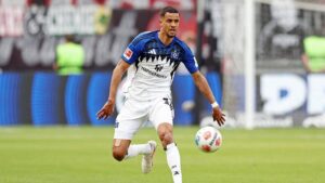 Robert Glatzel im Trikot des Hamburger SV blickt während eines Spiels konzentriert auf das Spielfeld.