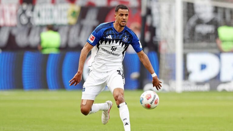 Robert Glatzel im Trikot des Hamburger SV blickt während eines Spiels konzentriert auf das Spielfeld.